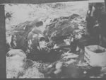 Le Dr Harry Ebbs tamise de la terre sur le site d'exhumation au cimetire de Mowat
