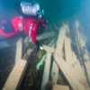 An underwater archaeologist measures the muzzle bore diameter of one of two cannons of HMS Erebus