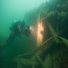 Un plongeur filme le poteau et le fémelot de la poupe du HMS Investigator