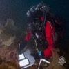 Using specialized underwater paper, an underwater archaeologist takes notes as part of the marine biology pilot project