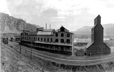 [ The commune's KC jam factory in the late 1920s.  On the left is the Brilliant train station, from which Peter V. Verigin departed October 28, 1924, Unknown, Doukhobor Discovery Centre, Castlegar, BC Pan 02 ]