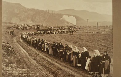 [ A crowd lines the road from Verigin's home, waiting for the bier to pass, Hughes Bros, Doukhobor Discovery Centre, Castlegar, BC  ]